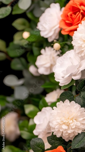 Lush arrangement of white and orange blossoms with green foliage against a dark background