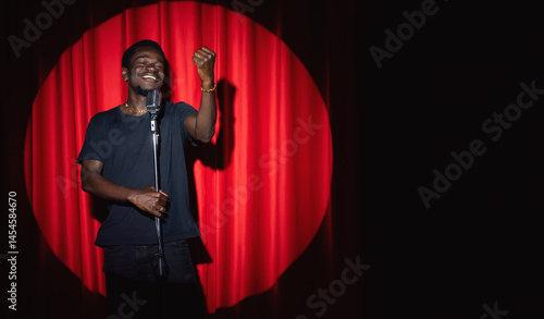 Canvas-taulu African, american man comic in costume performing standup monologue on stage with red curtains