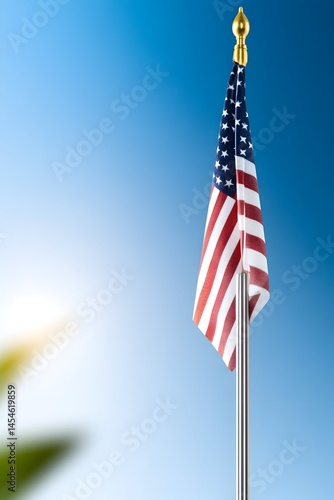 A small American flag on a pole against a bright blue sky
