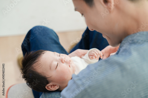 眠っている赤ちゃんを抱く男性