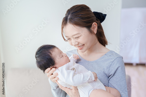 赤ちゃんを抱いて微笑む女性