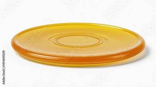 A clear, amber plastic disc with concentric oval design on a white surface