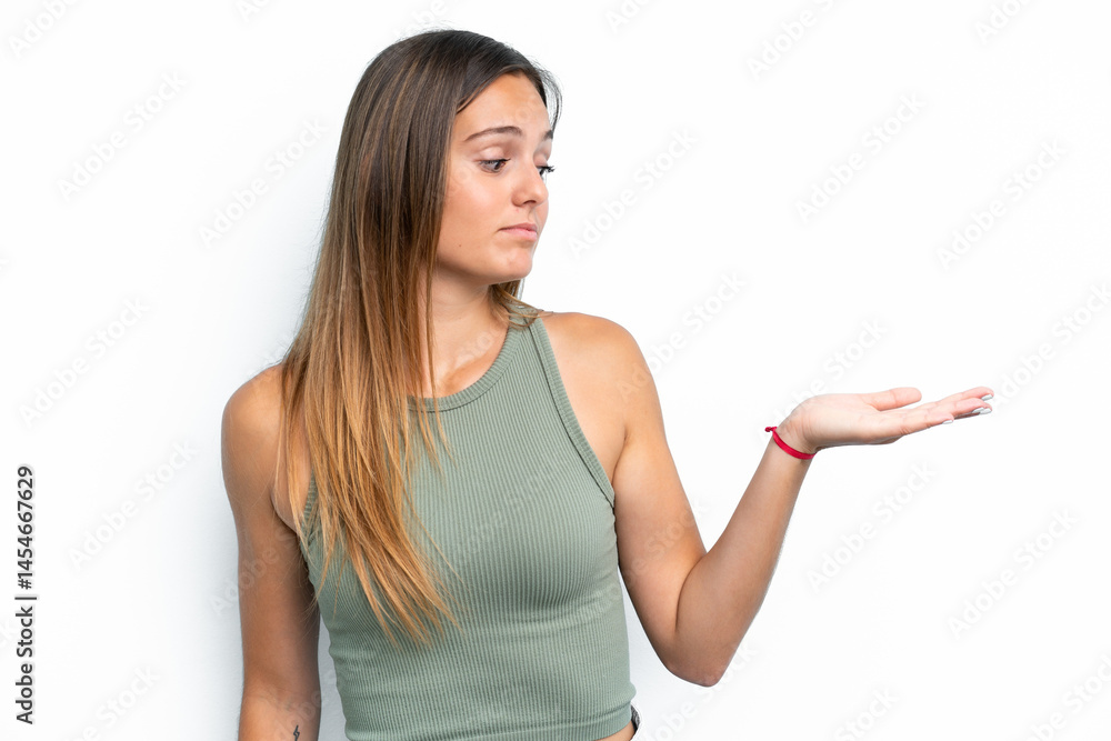 Young caucasian woman isolated on white background holding copyspace with doubts Young caucasian woman isolated on white background holding copyspace with doubts