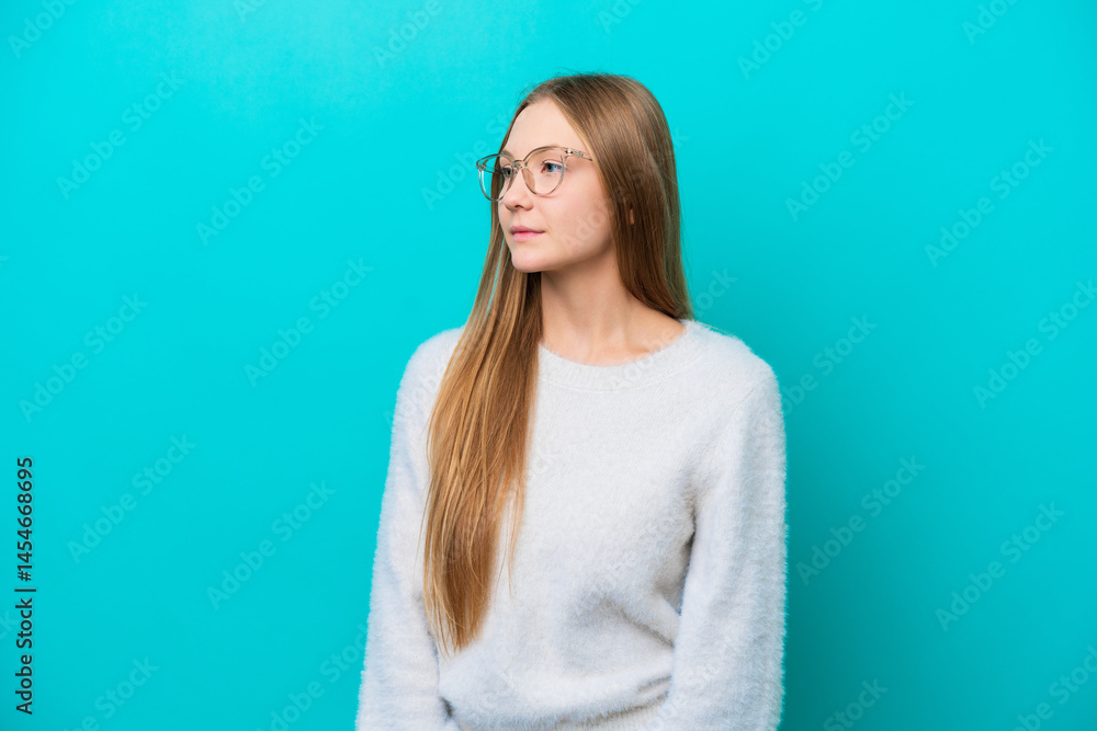 Fototapeta premium Young Russian woman isolated on blue background looking to the side
