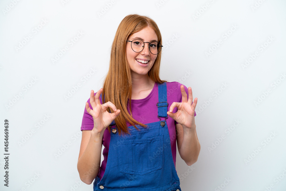 Young redhead woman isolated on white background showing ok sign with two hands Young redhead woman isolated on white background showing ok sign with two hands