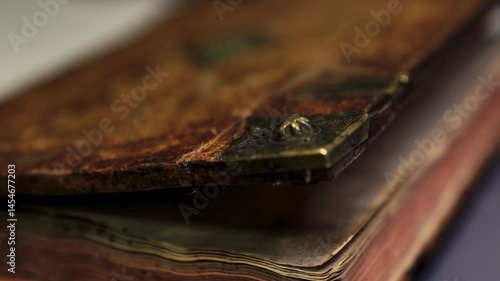 Macro footage of an ancient books spine and metal elements. Slow glide reveals the textures and age. Perfect for museum or educational content