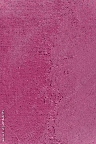 A wall with a pink color and a rough texture. The wall has a few scratches and marks.