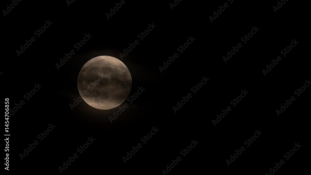 Scary rising full red moon crossed by dark clouds in a black sky Scary rising full red moon crossed by dark clouds in a black sky