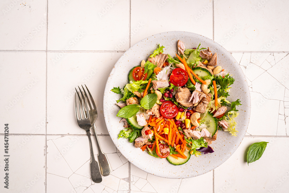 Salad with chicken meat on white background, top view. Fresh vegetable salad with chicken. Meat salad with chicken fillet and fresh vegetables on plate. High quality photo