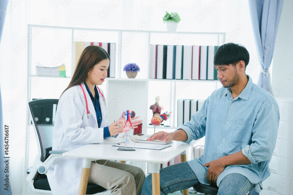 Obraz premium Asian female doctor examining male patient who is suffering from stomach pain, digestive problems, heart disease.