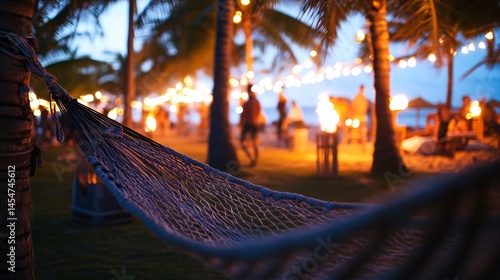 Obraz na płótnie Close up of hammock mesh stretched between palm trees, tiki torches and beach party in background w salonie