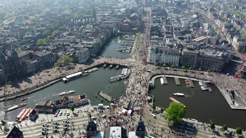 Aerial drone footage of Amsterdam city center during King's Day the Damrak is an avenue and partially filled in canal downtown running between the Central railway station and Dam Square 4k resolution