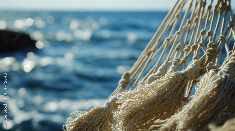 Close up of hammock tassels blowing near seaside breeze, blurred ocean horizon in backdrop