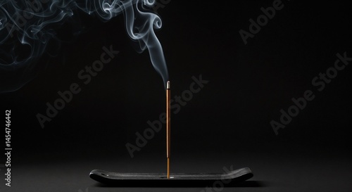 Obraz na płótnie Burning incense stick producing smoke in minimalist holder on dark background, calming atmosphere w salonie