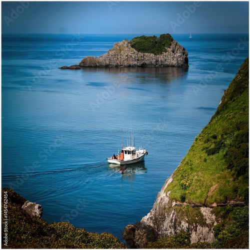 Fishing Boat Sailing Near Rocky Island
