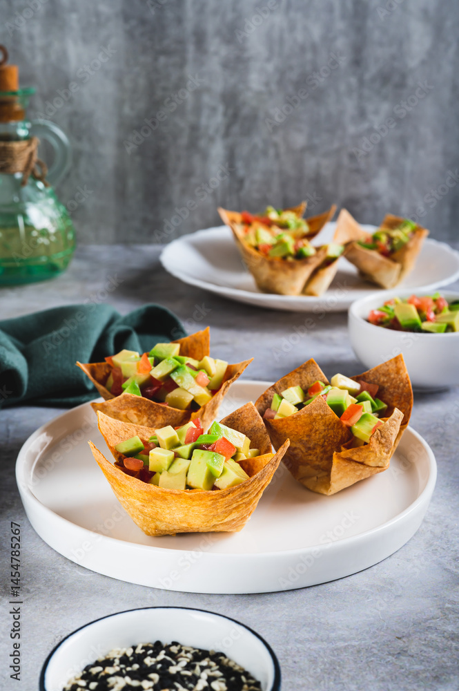 Appetizing cups of guacamole in pita bread on a plate on the table vertical view Appetizing cups of guacamole in pita bread on a plate on the table vertical view