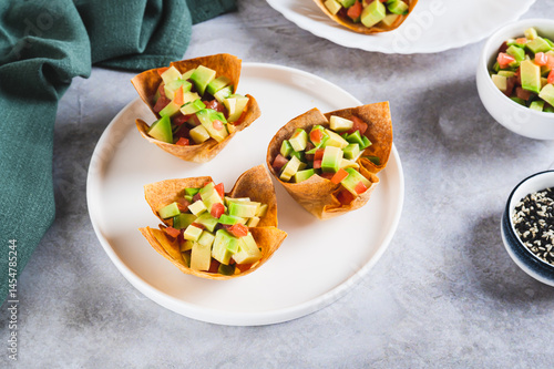 Mini baked pita cups with guacamole on a plate on a table