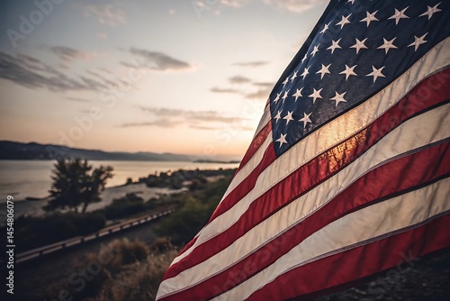 American flag waves proudly against a beautiful sunset over a calm lake landscape