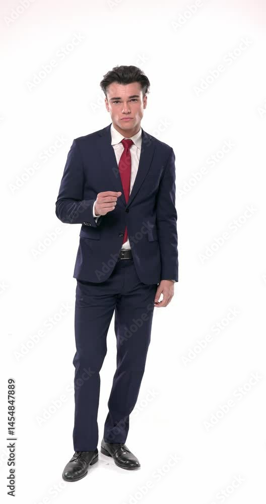attractive young businessman in navy blue suit moving and posing before putting hand in pockets and smiling in front of white background attractive young businessman in navy blue suit moving and posing before putting hand in pockets and smiling in front of white background