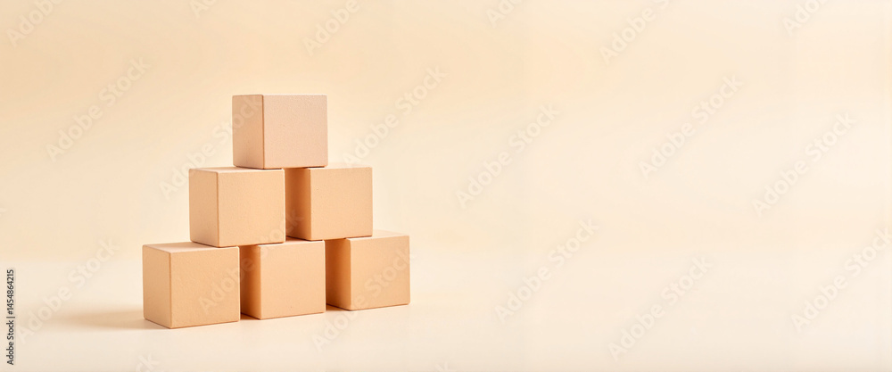 Obraz premium Cubes forming a pyramid structure on soft neutral backdrop, creativity
