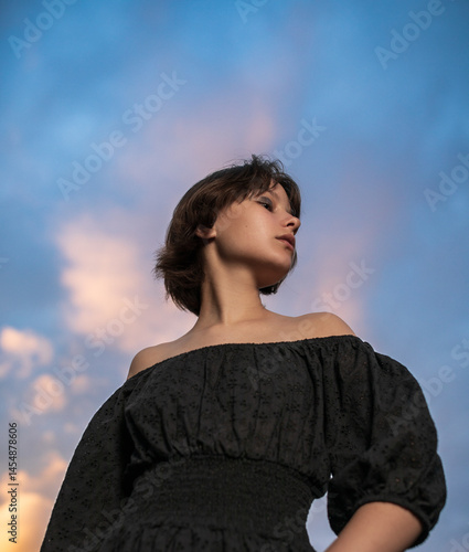 Obraz na płótnie Portrait of beautiful serious teen girl against cloudy sky w salonie