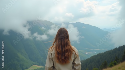 Obraz na płótnie Young Woman Standing on a Misty Mountain Peak, Overlooking the Valleys Below w salonie