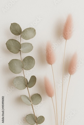 Decorative Arrangement of Green Foliage and Soft Pink Accents on a Light Back...