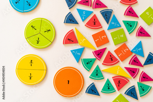 Colorful fraction educational tools arranged on a white surface for interactive learning and teaching purposes. education,  back to school