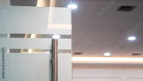 Elegant frosted glass door with stainless steel handle in modern office space