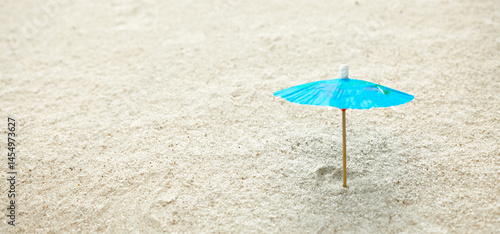 Fototapeta Naklejka Na Ścianę i Meble -  toy sun umbrella on sand, free space, background for beach holiday and design