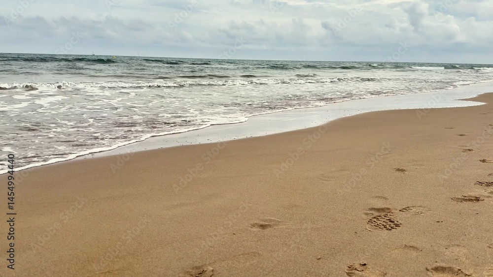 A Serene Ocean View with Gentle Waves Crashing on a Sandy Shoreline Invites Relaxation A Serene Ocean View with Gentle Waves Crashing on a Sandy Shoreline Invites Relaxation