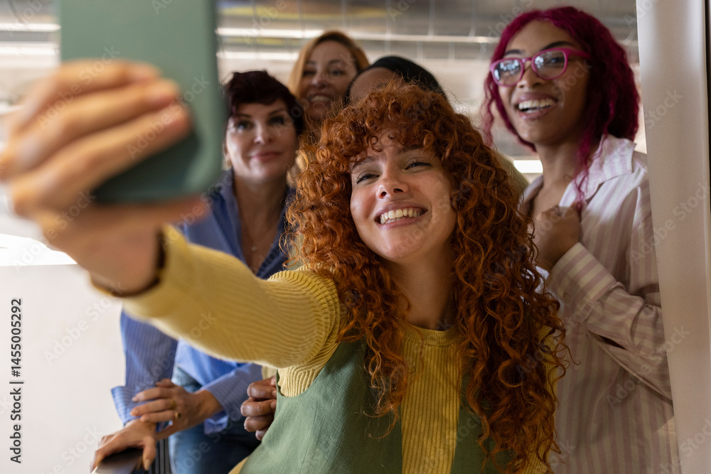 Obraz premium Coworkers taking a selfie in the office hallway