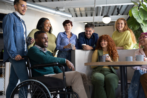 Coworkers enjoying a coffee break, chatting and laughing together in an inclusive workplace