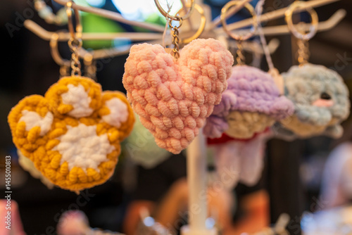 A pink crocheted heart keychain hangs amongst other colorful keychains