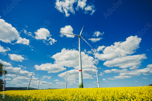 Obraz na płótnie Windmill for generating energy against a blue sky. Windmill in a rural area in Europe. w salonie