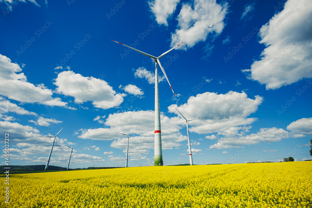 Wind energy generation using windmills. Electricity is produced by a wind turbine against a blue sky background. Energy production in a windy green area. Ecological energy production