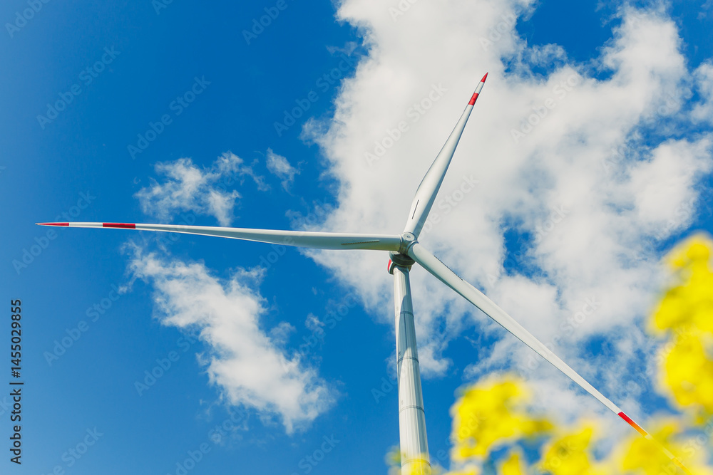 Ecological energy generation by windmills from the wind. Windmill field. Wind turbines generating energy against a clear blue sky. Wind turbines generating clean renewable energy in a rural field.