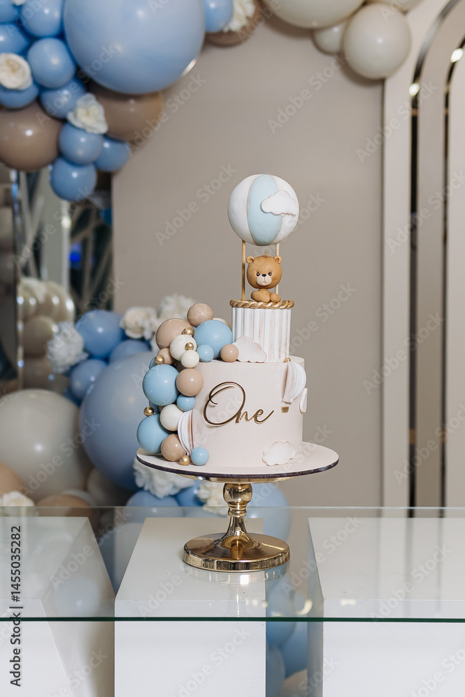 Sweet cake for a child's birthday decorated with a teddy bear. Two-story cake for a child. 1st birthday party for a child.
