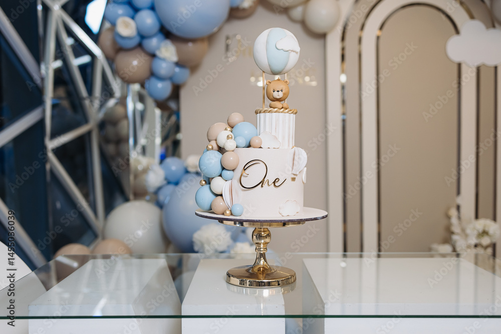 Sweet cake for a child's birthday decorated with a teddy bear. Two-story cake for a child. 1st birthday party for a child.