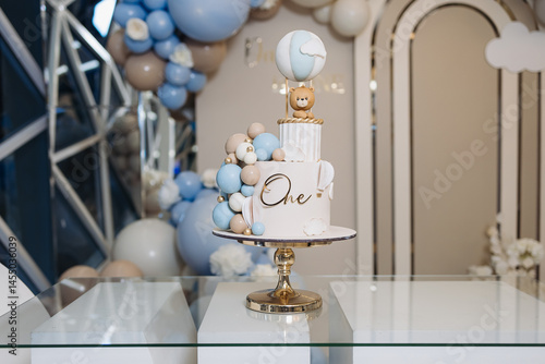 Obraz na płótnie Sweet cake for a child's birthday decorated with a teddy bear. Two-story cake for a child. 1st birthday party for a child. w salonie