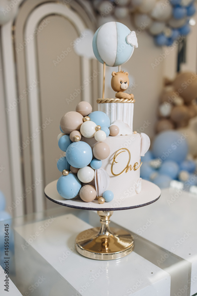 Sweet cake for a child's birthday decorated with a teddy bear. Two-story cake for a child. 1st birthday party for a child.