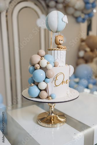 Obraz na płótnie Sweet cake for a child's birthday decorated with a teddy bear. Two-story cake for a child. 1st birthday party for a child. w salonie