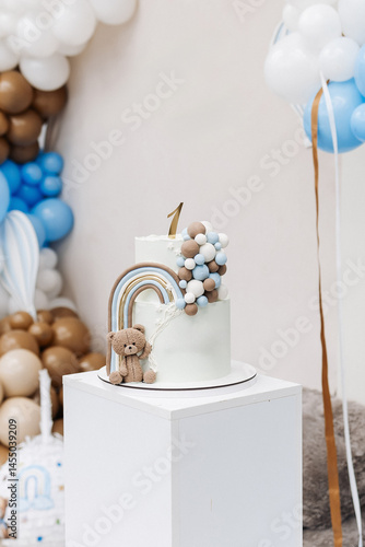 Two-story sweet cake decorated with a teddy bear for a birthday celebration. Cake for a child's first birthday. CAKE for a one-year-old child.