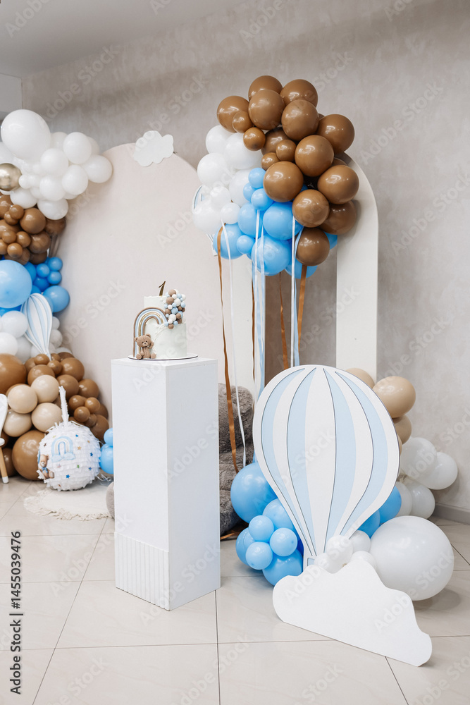 Two-story sweet cake decorated with a teddy bear for a birthday celebration. Cake for a child's first birthday. CAKE for a one-year-old child.