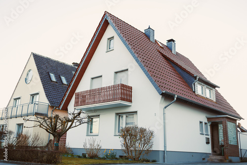 Obraz na płótnie Exterior facade of the house. Landscape design of the house area. European house. Roof on the house made of tiles. w salonie