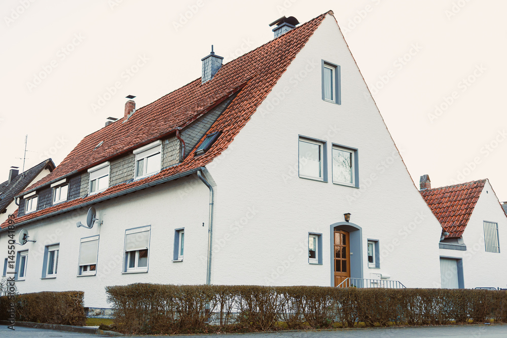 Exterior facade of the house. Landscape design of the house area. European house. Roof on the house made of tiles.