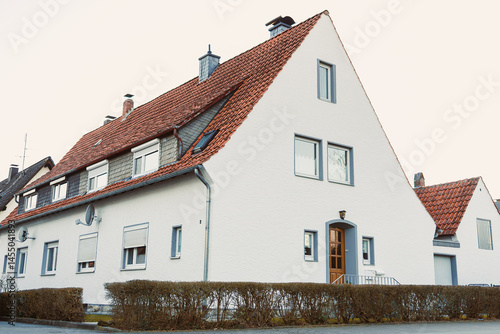 Obraz na płótnie Exterior facade of the house. Landscape design of the house area. European house. Roof on the house made of tiles. w salonie