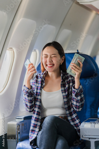 Obraz na płótnie Happy Woman Holding Money and Credit Card on Airplane w salonie