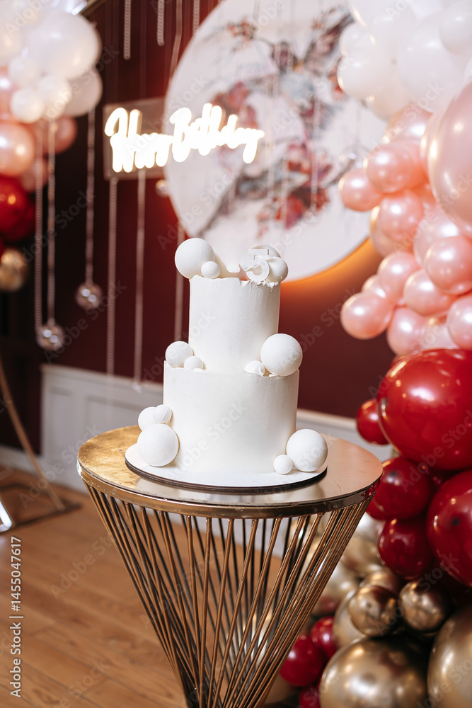 Pink first birthday cake with teddy bear figurine. Soft pastel colors and festive decoration create a warm, festive atmosphere. Sweet cake for a one-year-old birthday girl
