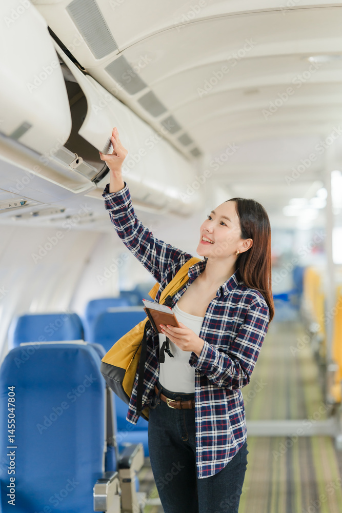 Woman Placing Luggage in Airplane Overhead Compartment